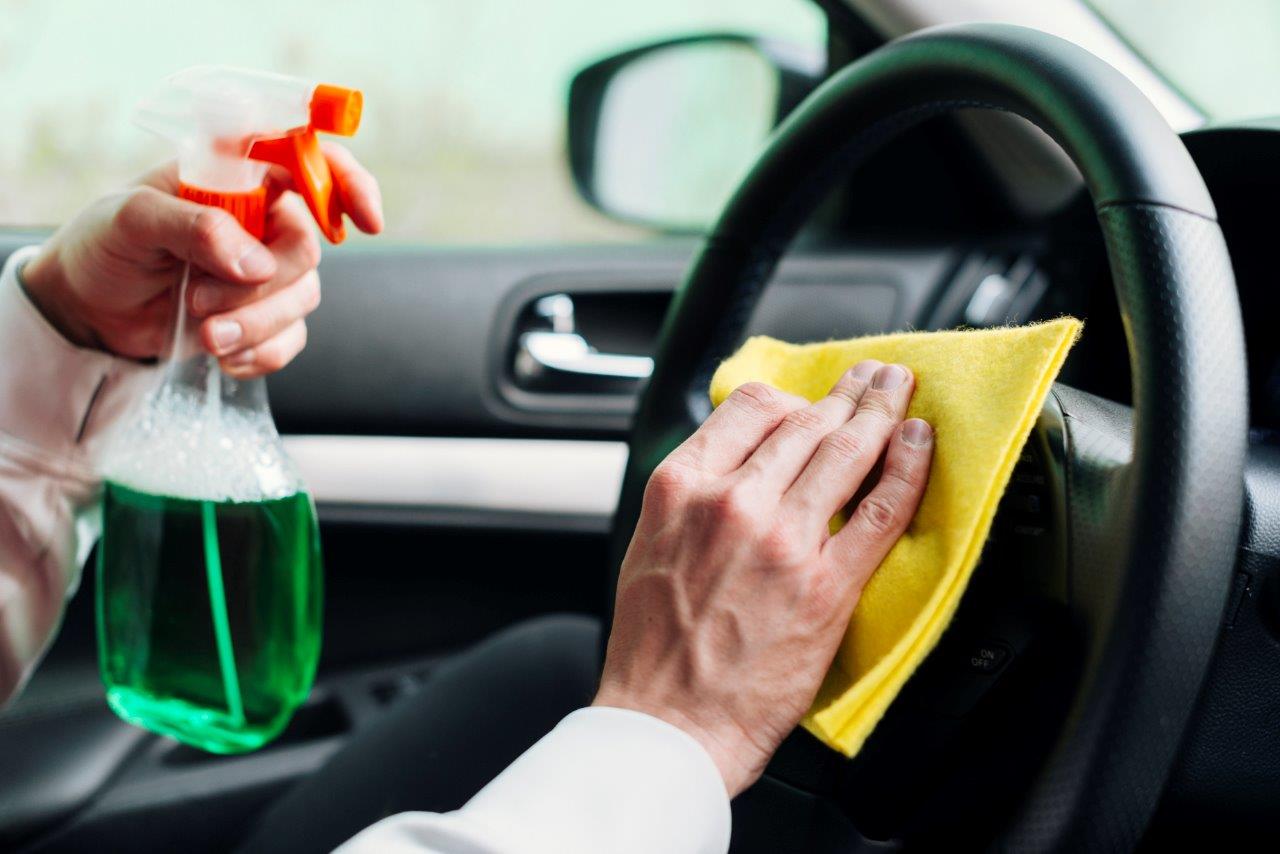 man cleaning steering wheel