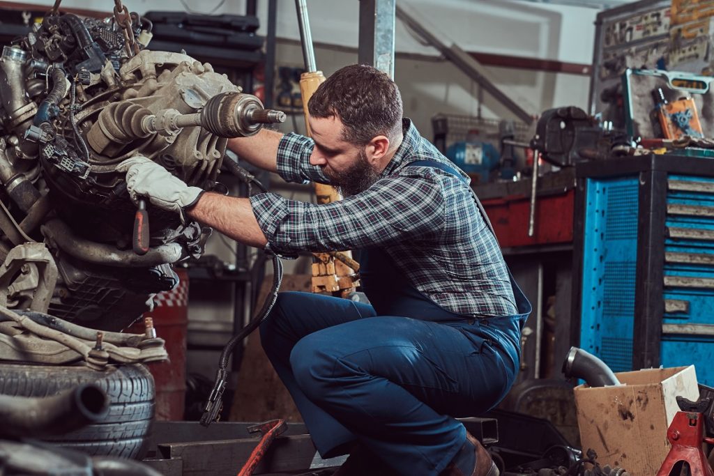 mechanic repairs the car engine in the garage. Service station.