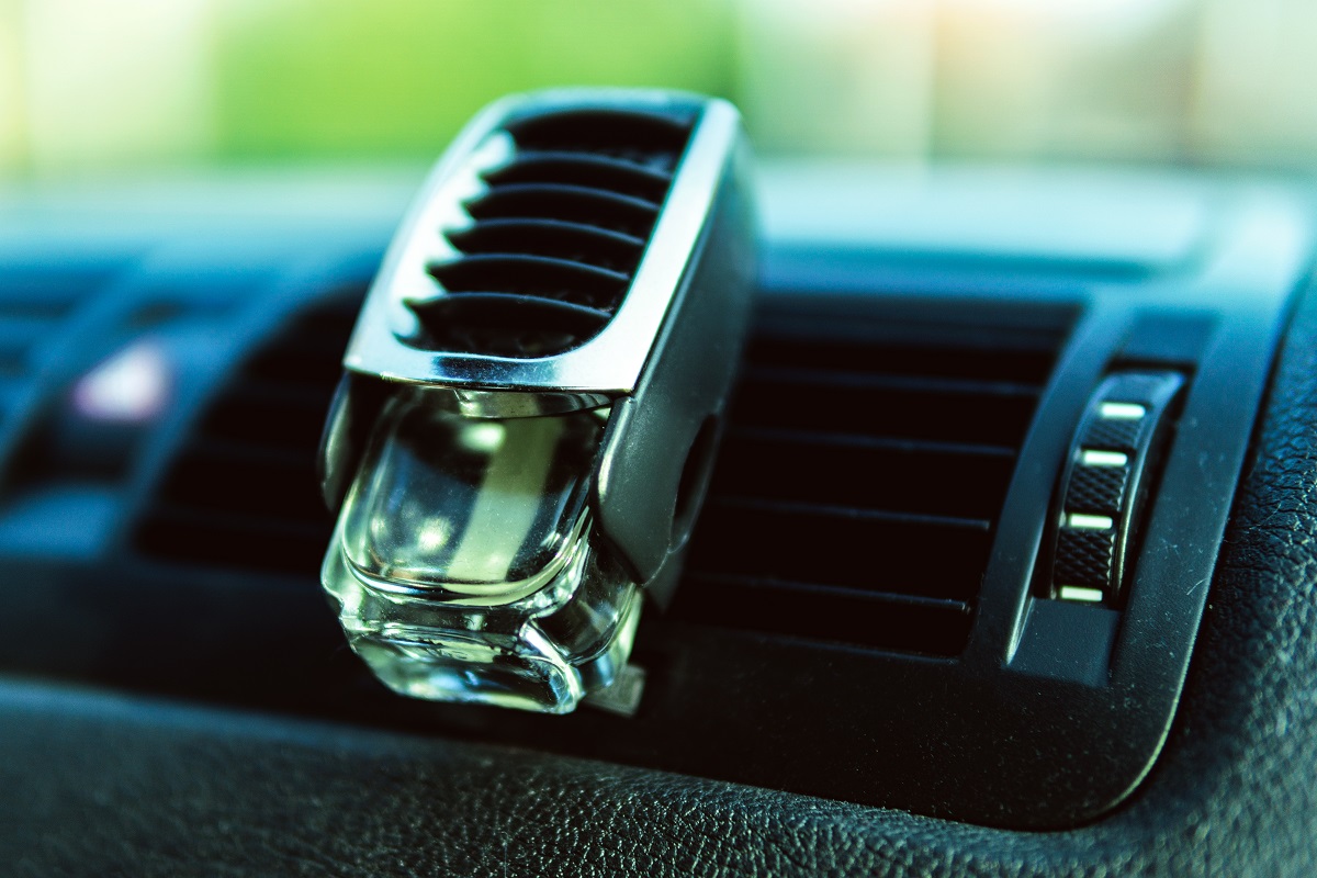 Air freshener in car vent, black interior, car deflectors, fresh air.