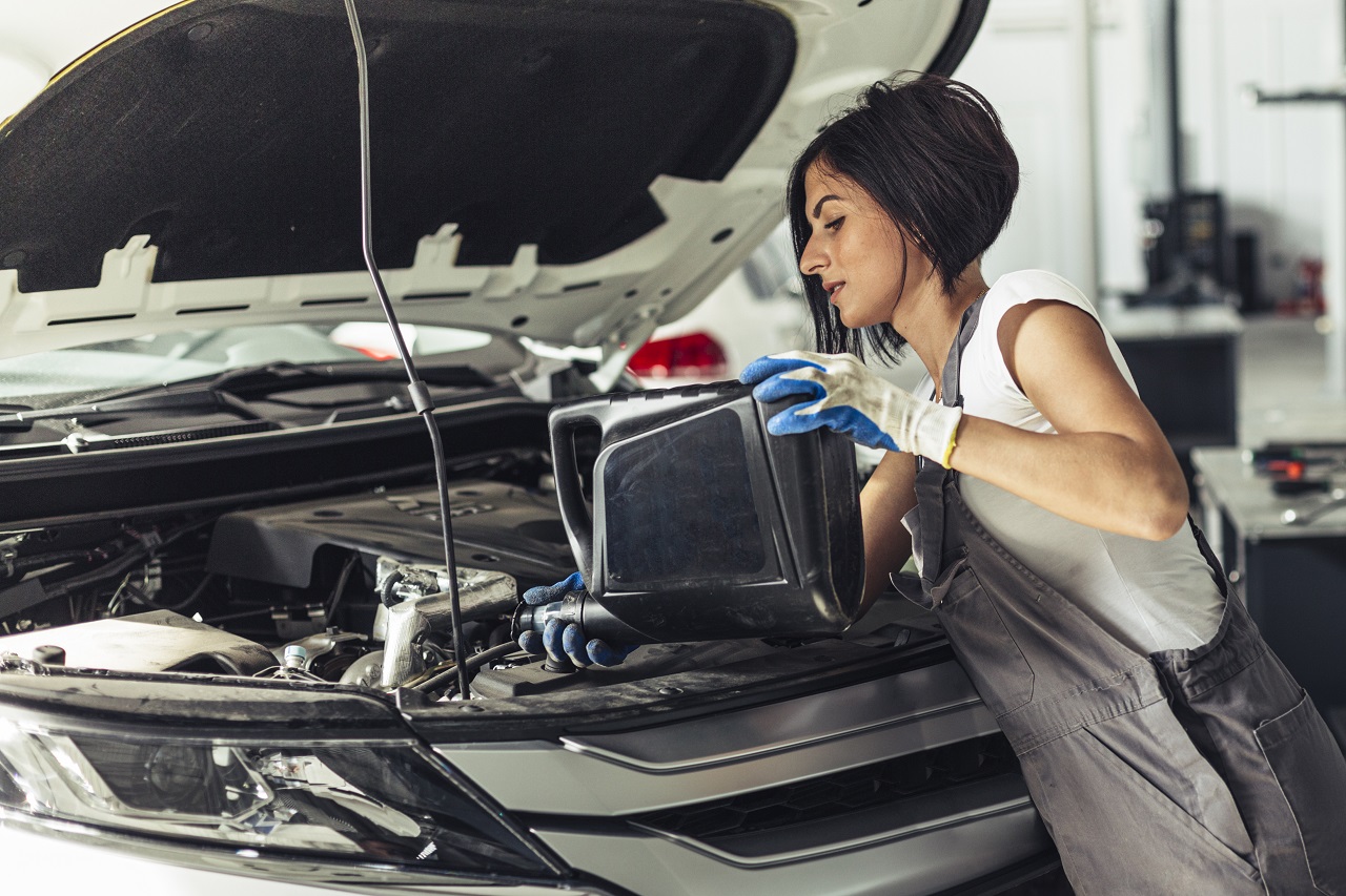 woman changing car oil